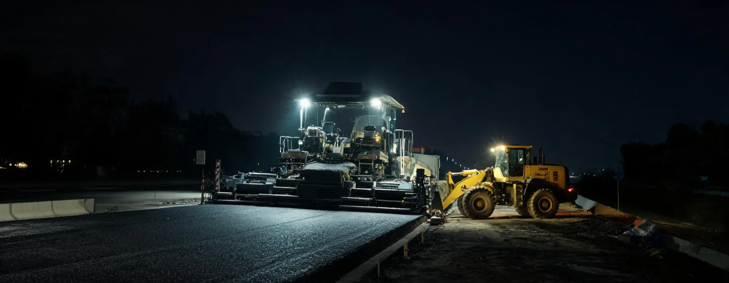 Night construction site with LED-lit machines