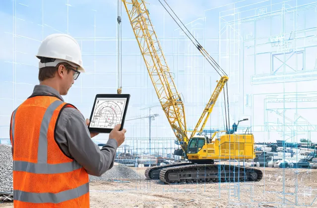 Engineer reviewing crane boom load chart on tablet at jobsite
